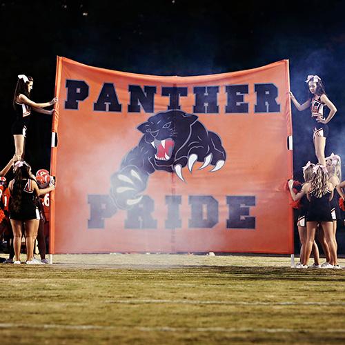 cheerleaders holding a banner panth