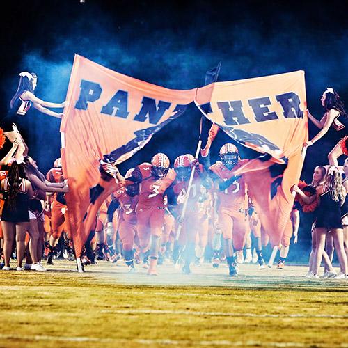 football team entrance with banner