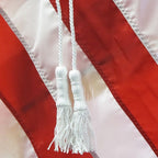 white tassels on red flag
