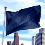 Dark blue flag made of durable fabric waving on a pole above city buildings against a cloudy sky, Solid Colored Flags - Premier Nylon