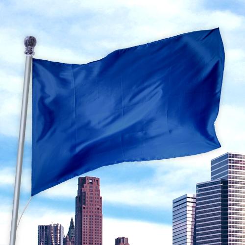 Blue flag made of durable fabric waving on a pole above city buildings, Solid Colored Flags - Premier Nylon product.