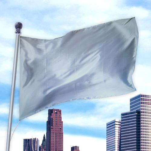 Solid Colored Flags - Premier Nylon flag in silver color flying on a pole against a city skyline and blue sky background.