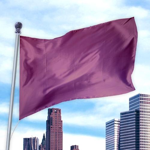 Solid Colored Flags - Premier Nylon waving in the wind against a city skyline under a blue sky.