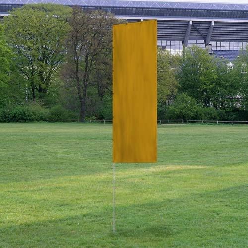 Solid Tall Advertising Flags in a plain yellow fabric set up on a green grassy field with trees and a stadium in the background.