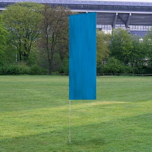 Solid Tall Advertising Flags in a solid blue color displayed outdoors on a grassy field with trees and a stadium structure in the background.