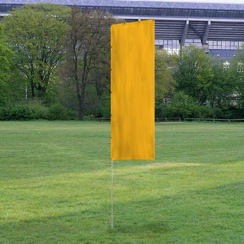 Solid Tall Advertising Flags standing on green grass field with a bright yellow fabric against a background of trees and stadium seating.