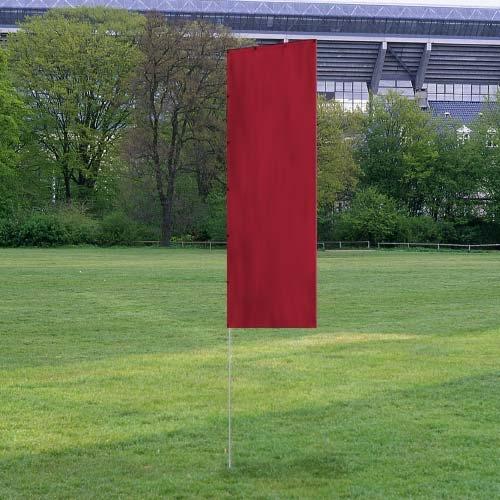 Solid Tall Advertising Flags in solid red color standing on a grassy field with trees and a stadium in the background