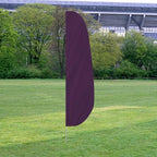 Solid Color Feather Flags standing on a grassy field with trees and a stadium structure in the background, featuring a deep purple color.