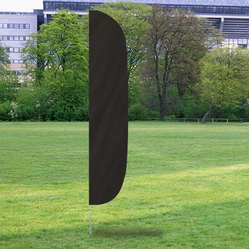 Solid Color Flutter Flags in black standing upright on a grassy field with trees and buildings in the background.