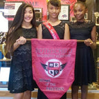 three girls holding banner dress