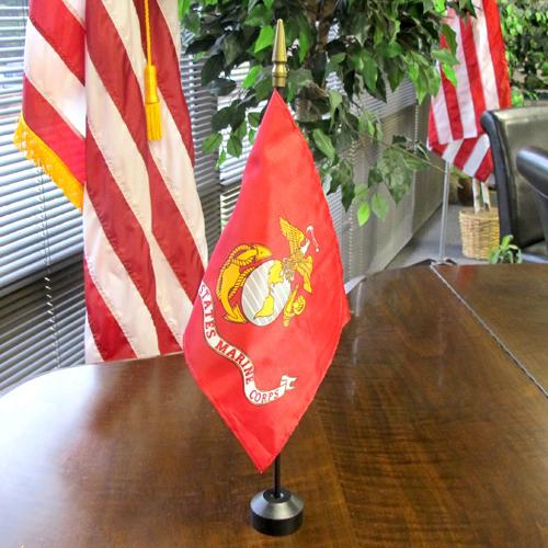 USMC flag on a desk with plants