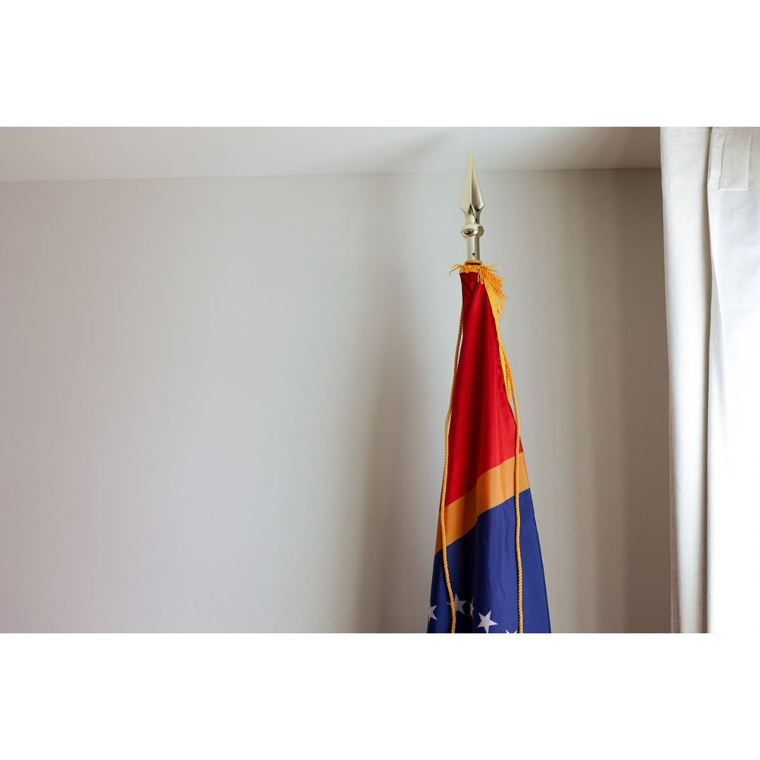Indoor Mississippi state flag on pole with spear finial and gold cord tassels