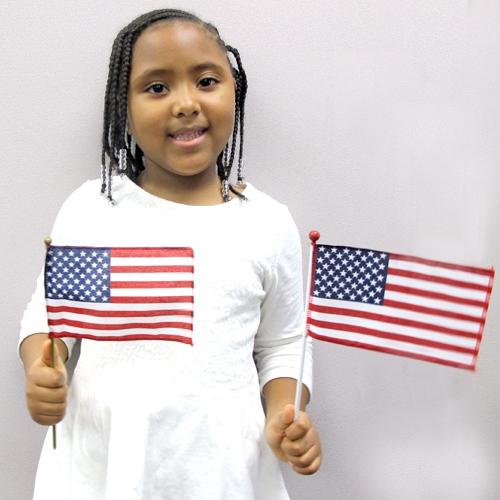 Kid holding two mini U.S. Flags
